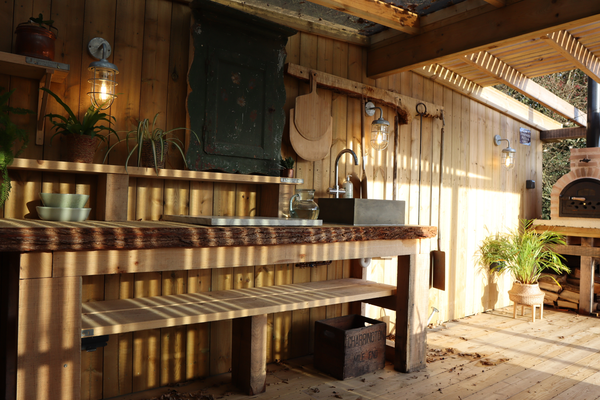 Live-edge workbench with stone sink under the covered kitchen